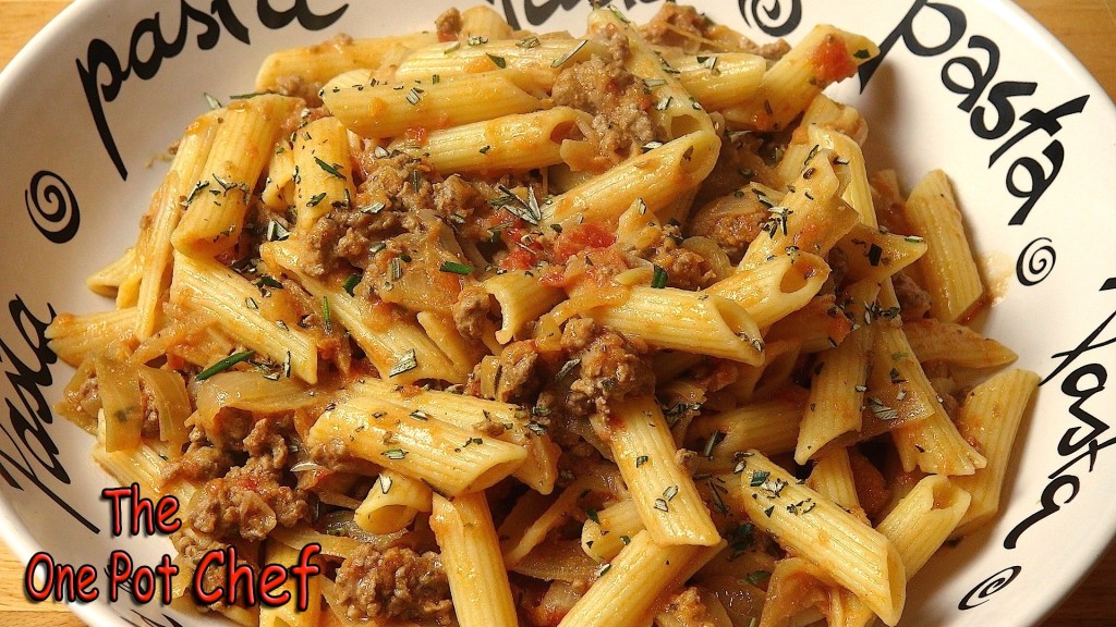 A bowl of pasta with penne, minced meat, and herbs, served in a dish that features the word 'pasta'.