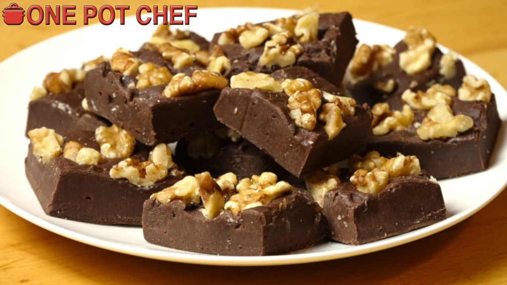 A plate of chocolate fudge pieces topped with chopped walnuts.