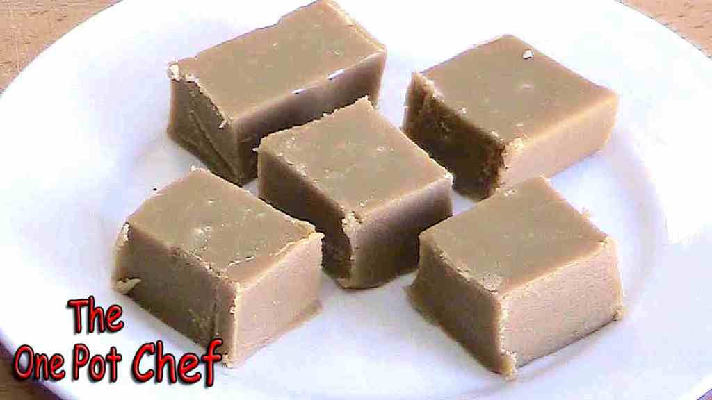 Five pieces of creamy fudge arranged on a white plate.