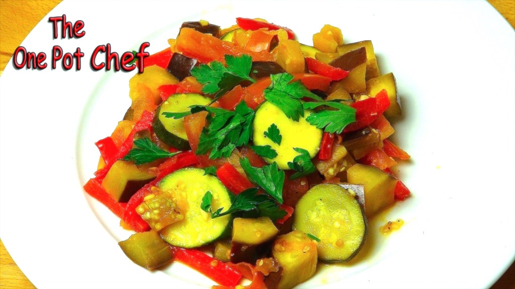 A vibrant vegetarian dish featuring chopped zucchini, red bell peppers, eggplant, and diced tomatoes garnished with fresh parsley, served on a white plate.