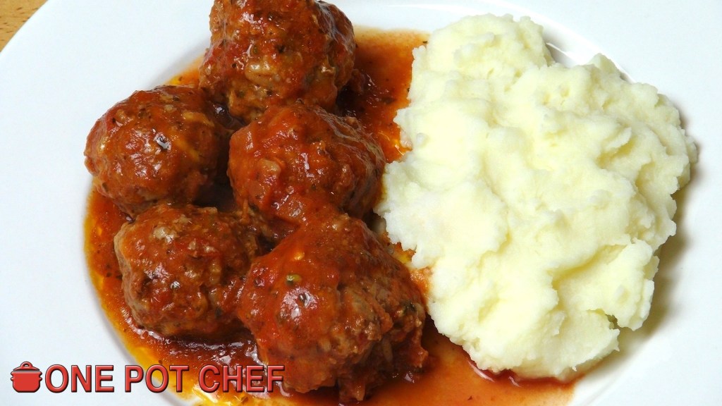 A plate of meatballs in tomato sauce served with creamy mashed potatoes.